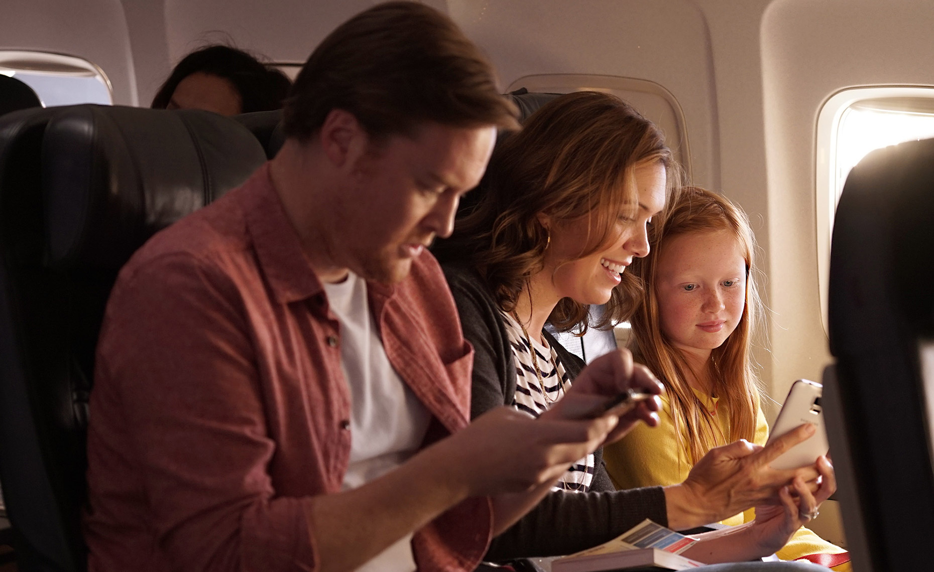 Commercial Travel Photography by Roger Snider - Family on plane to Mexico vacation .